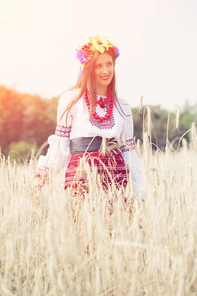 Frau trägt ukrainische Nationalkleidung im Weizenfeld — Stockfoto