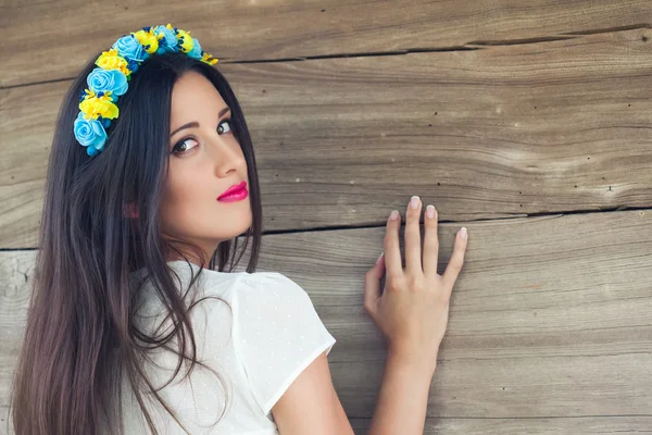 青と黄色の花輪を身に着けて美しい若い女性 — ストック写真