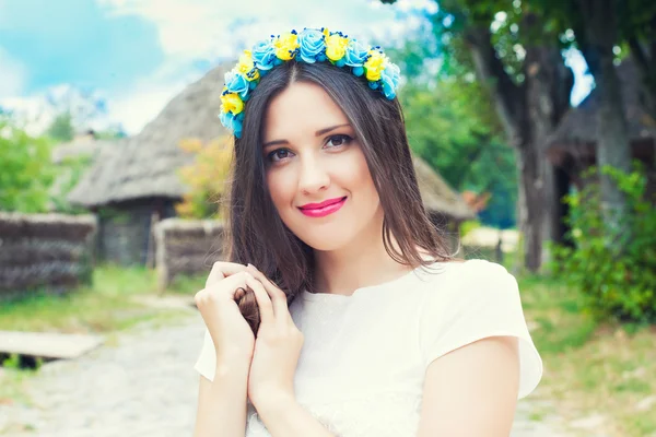 Mooie jonge vrouw dragen blauwe en gele krans — Stockfoto