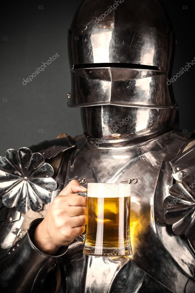 Knight holding mug of beer and twohanded sword — Stock Photo