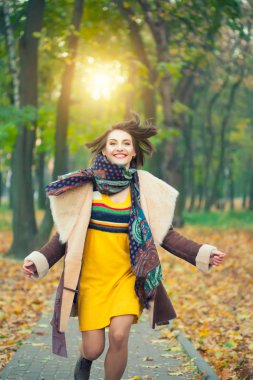 Sonbahar parkında koşan kadın