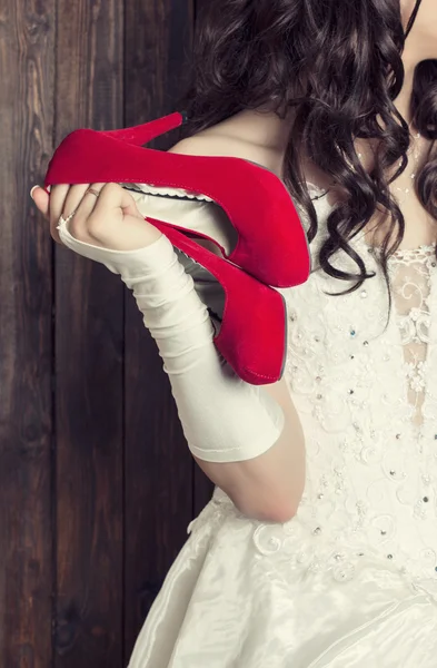 Noiva segurando um par de sapatos — Fotografia de Stock