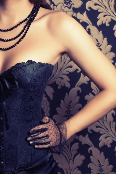 Frau trägt schwarzes Korsett und Perlen — Stockfoto