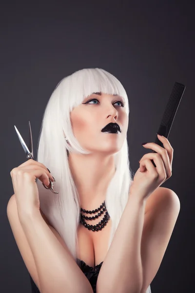 Femme posant avec des ciseaux et une brosse à cheveux — Photo
