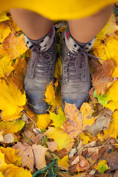 Piernas en botas en las hojas de otoño —  Fotos de Stock