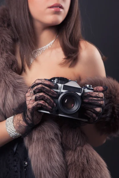 Женщина держит винтажную камеру — стоковое фото