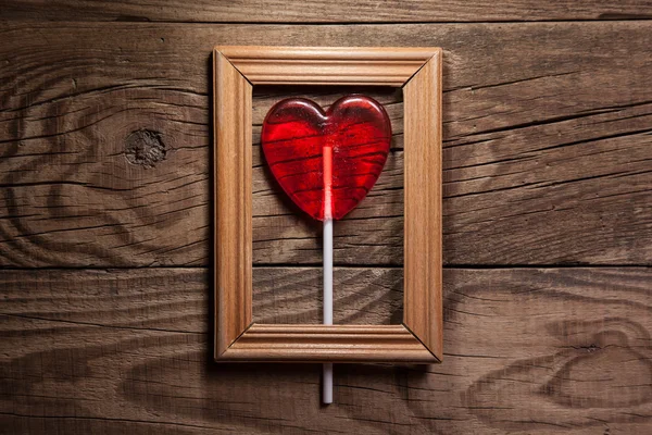 Lollipop heart on vintage frame — Stock Photo, Image