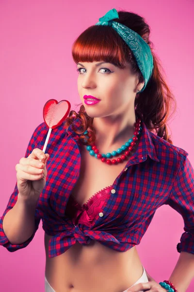 Girl  with red heart-shaped lollipop — Stock Photo, Image