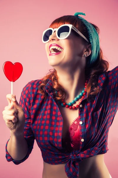 Flicka med röd hjärtformad lollipop — Stockfoto