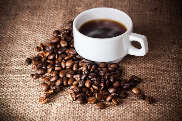 Coffee cup on coffee beans — Stock Photo, Image