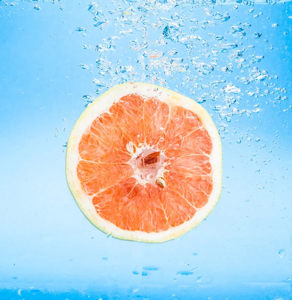 Grapefruit in water with bubbles — Stock Photo, Image