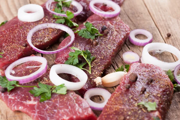 Raw beef steak with onions — Stock Photo, Image