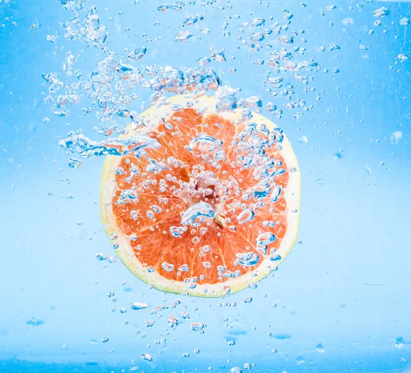 Grapefruit in water with bubbles — Stock Photo, Image