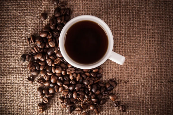 Kahve fincanı kahve çekirdekleri üzerine — Stok fotoğraf