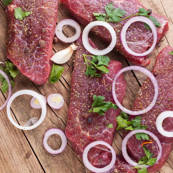 Raw beef steak with onions — Stock Photo, Image