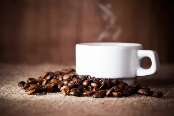 Coffee cup on coffee beans — Stock Photo, Image