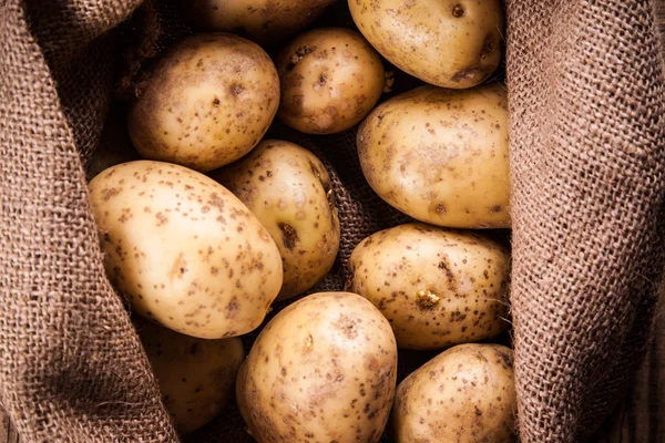 Potatoes in burlap sack — Stock Photo, Image