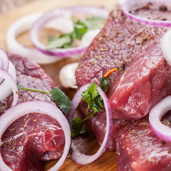 Raw beef steak with onions — Stock Photo, Image