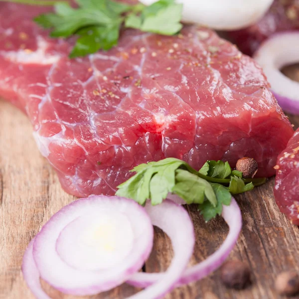 Raw beef steak with onions — Stock Photo, Image