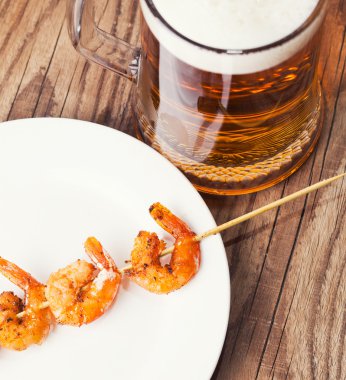 Bardak bira ile plaka üzerinde ızgara karides