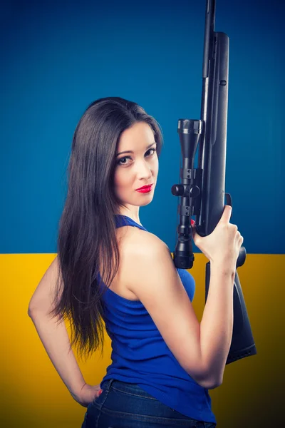Jeune femme posant avec un fusil — Photo