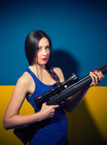 Jeune femme posant avec un fusil — Photo