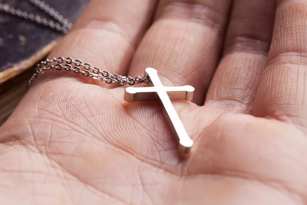 Silver cross in a hand — Stock Photo, Image