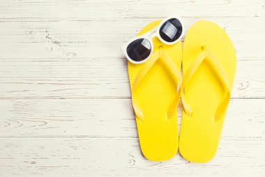Sarı flip flop ve güneş gözlüğü