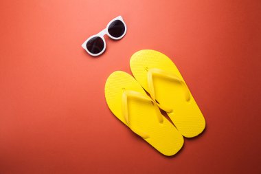 Sarı flip flop ve güneş gözlüğü