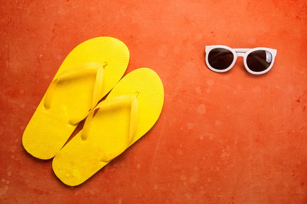 Chinelos amarelos e óculos de sol — Fotografia de Stock