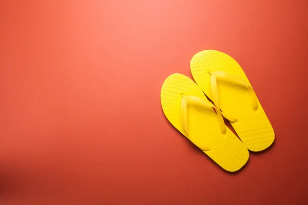 Yellow flip-flops on a red — Stock Photo, Image