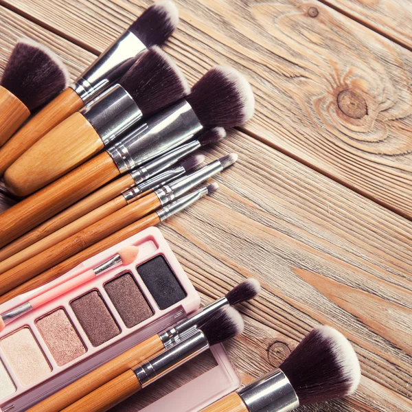 Brushes with cosmetics scattered chaotically — Stock Photo, Image