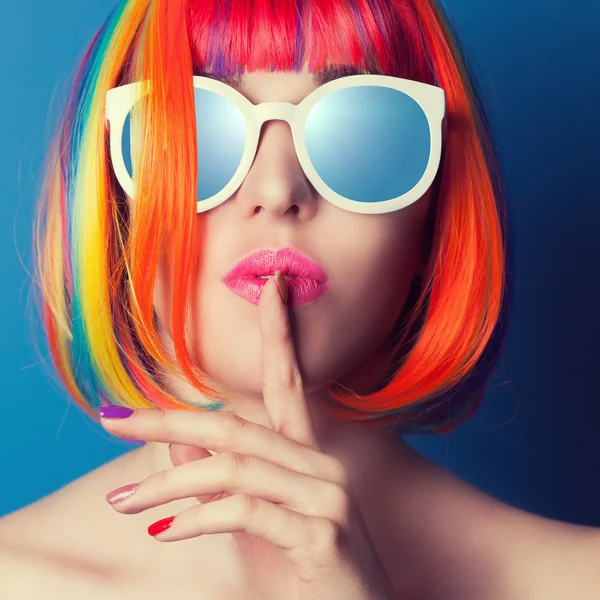 Beautiful woman wearing colorful wig and white sunglasses agains — Stock Photo, Image