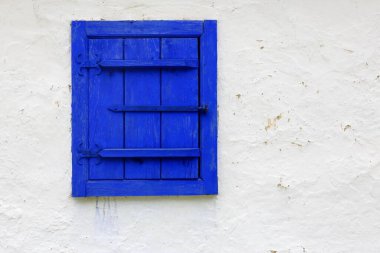 Beyaz bir duvardaki eski mavi ahşap pencere Derin mavi kompozisyon