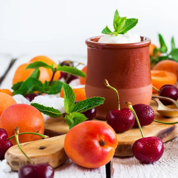 Färsk jogurt med organiska mogna aprikoser och körsbär — Stockfoto