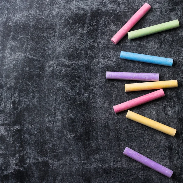 Stukken van school krijt op oude zwarte schoolbord — Stockfoto