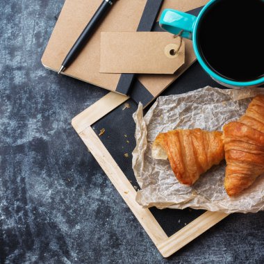 İş kırtasiye kruvasan kupa kahve grunge yazı tahtası üzerinde