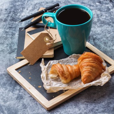 İş kırtasiye kruvasan kupa kahve grunge yazı tahtası üzerinde