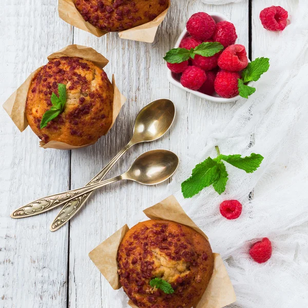Färska muffins med hallon på ett rustikt bord för frukost — Stockfoto