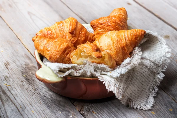 Croissants frais pour le petit déjeuner sur table rustique — Photo