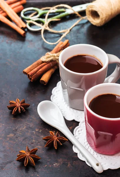 Cokelat panas di cangkir dengan rempah-rempah di atas meja gelap — Stok Foto