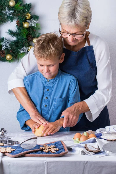 幸せなシニア成熟した女性 祖母と若い男の子 孫料理 練り生地 ベーキングパイ ケーキ クッキー 居心地の良いキッチンで家族の時間 家での季節の冬のクリスマス活動 — ストック写真