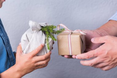 Yaratıcı sıfır noel konsepti. İnsanlar, çevre dostu el yapımı el yapımı el yapımı el yapımı el yapımı el işi kağıtları ve geleneksel Japon tarzı Furoshiki kumaşları ile sarıyorlar. Aile zamanı, şenlik hazırlığı.