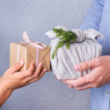 Yaratıcı sıfır noel konsepti. İnsanlar, çevre dostu el yapımı el yapımı el yapımı el yapımı el yapımı el işi kağıtları ve geleneksel Japon tarzı Furoshiki kumaşları ile sarıyorlar. Aile zamanı, şenlik hazırlığı.