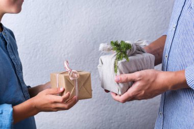Yaratıcı sıfır noel konsepti. İnsanlar, çevre dostu el yapımı el yapımı el yapımı el yapımı el yapımı el işi kağıtları ve geleneksel Japon tarzı Furoshiki kumaşları ile sarıyorlar. Aile zamanı, şenlik hazırlığı.