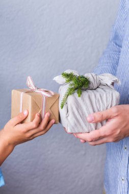 Yaratıcı sıfır noel konsepti. İnsanlar, çevre dostu el yapımı el yapımı el yapımı el yapımı el yapımı el işi kağıtları ve geleneksel Japon tarzı Furoshiki kumaşları ile sarıyorlar. Aile zamanı, şenlik hazırlığı.