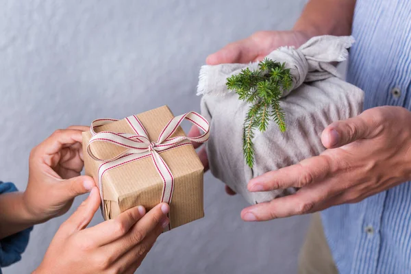 Yaratıcı sıfır noel konsepti. İnsanlar, çevre dostu el yapımı el yapımı el yapımı el yapımı el yapımı el işi kağıtları ve geleneksel Japon tarzı Furoshiki kumaşları ile sarıyorlar. Aile zamanı, şenlik hazırlığı.