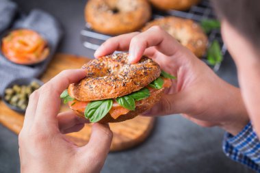 Yemek, öğle yemeği, brunch, tabakta yemek, kaplama konsepti. Genç adam el ele tutuşup füme somon, krem peynir, kapari ve fesleğen yemeye hazır.