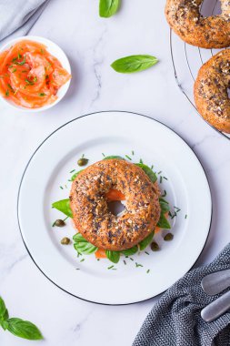 Yemek, öğle yemeği, brunch, tabakta yemek, kaplama konsepti. Somon füme simit, krem peynir ve kapari. Düz konum, üst görünüm arkaplan. 