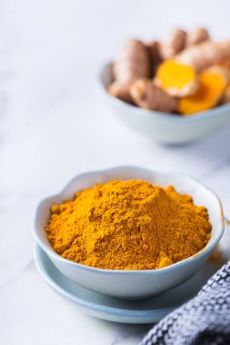 Yiyecek ve içecek, diyet beslenme, sağlık konsepti. Çiğ organik turuncu zerdeçal kökü ve toz, yemek masasında sokağa çıkma yasağı. Hint asıllı düşük kolesterol baharatları.